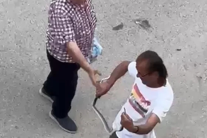 Paniğe sebep olan yılanı eliyle yakaladı
